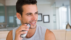 Man shaving his beard using electric shaver